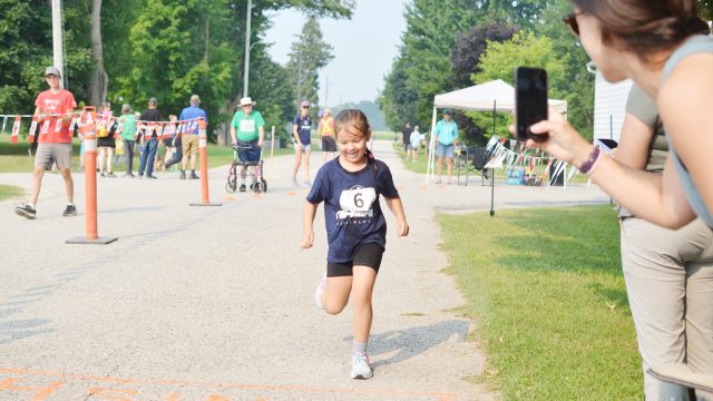 Annie Alexander (number 6) was all smiles as she crossed the finish line at the Tri-Umph Triathlon. (Denny Scott photo)