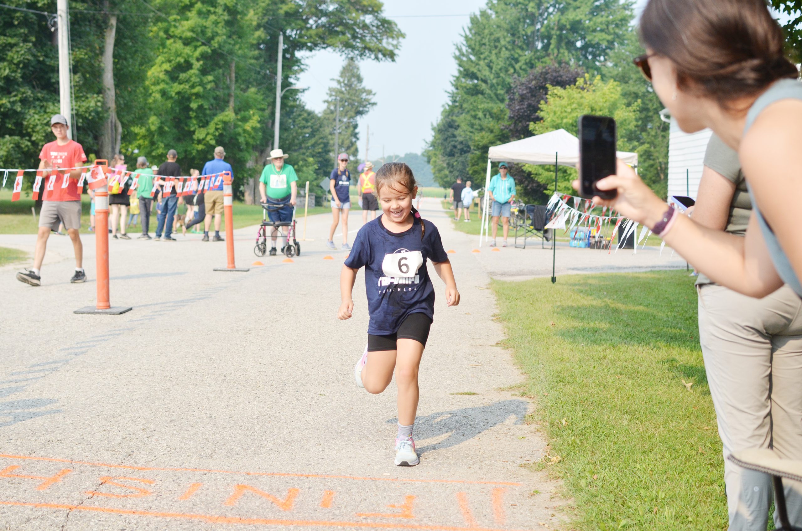 Annie Alexander (number 6) was all smiles as she crossed the finish line at the Tri-Umph Triathlon. (Denny Scott photo)